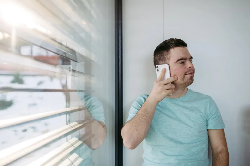 Disabled man with down syndrome smiling while talking on the phone